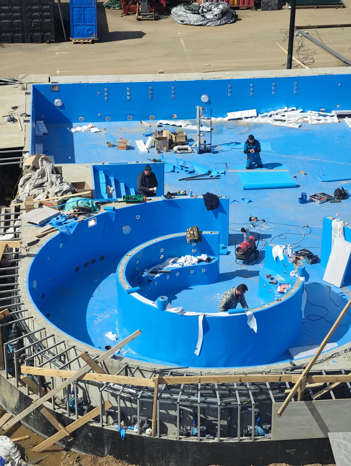 Membrane d'étanchéité bleue posée dans un bassin de piscine en construction